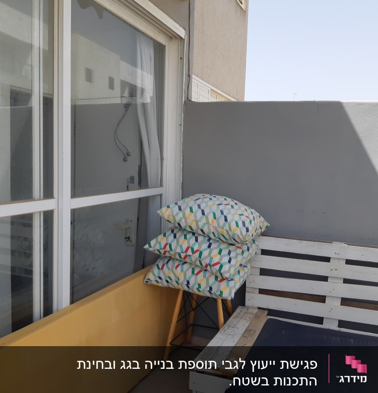 מרפסת עם כריות צבעוניות על כיסא עץ